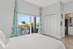 1 of 2 upstairs master bedrooms with ensuite bathroom and direct access to balcony that overlooks the pool, canal, and views of the Atlantic.